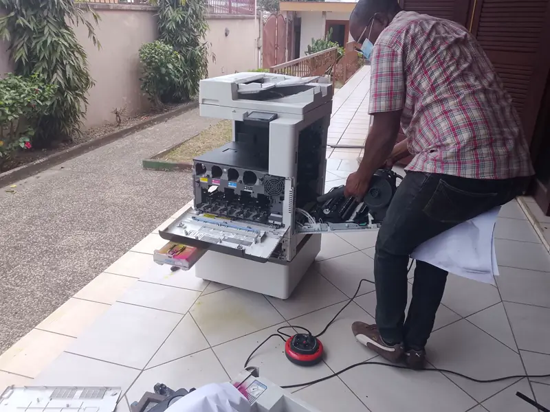 Technicien ouvrant un copieur multifonction pour l'entretenir